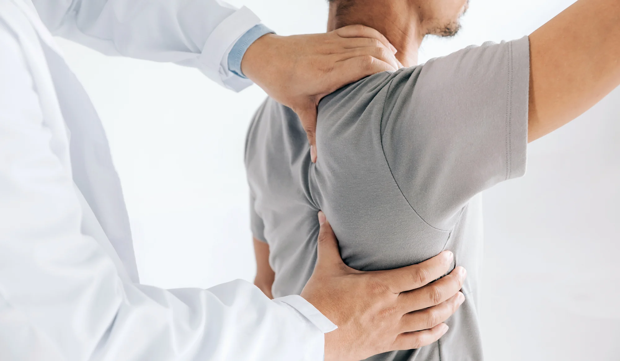 Chiropractor examining a patient's shoulder