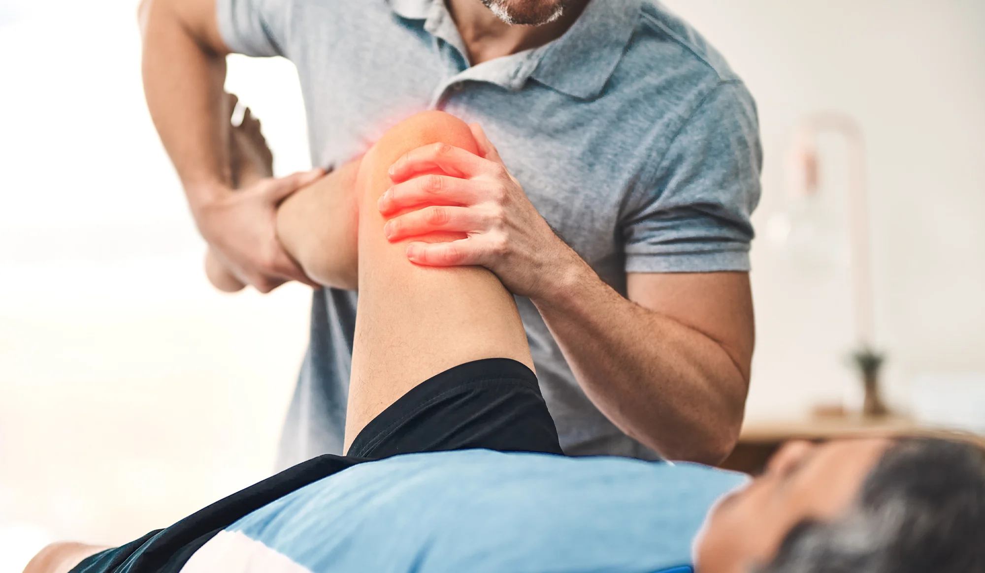 Chiropractor treating a patient's painful knee