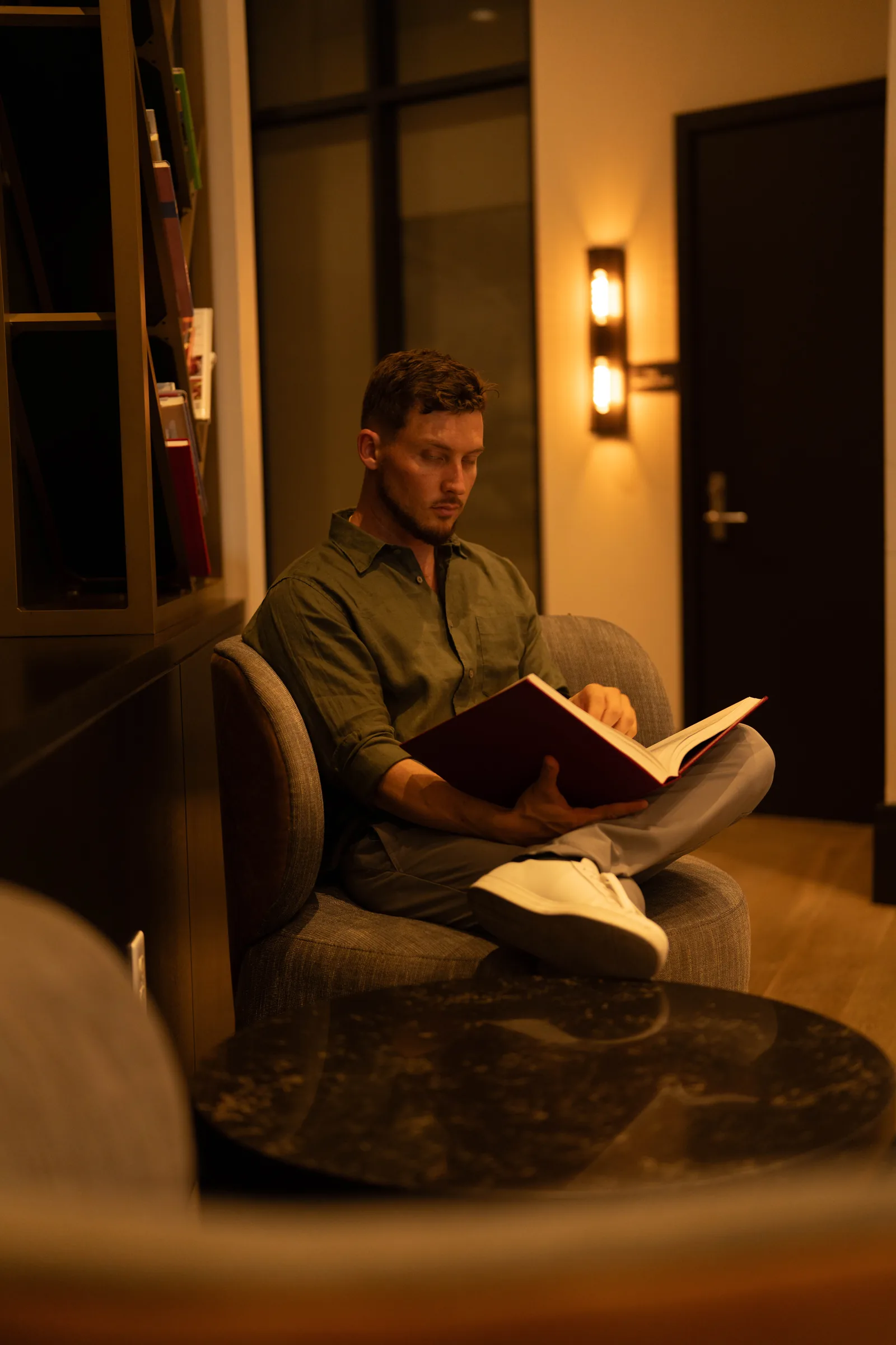 Dr. Jarod Ward reading in an armchair